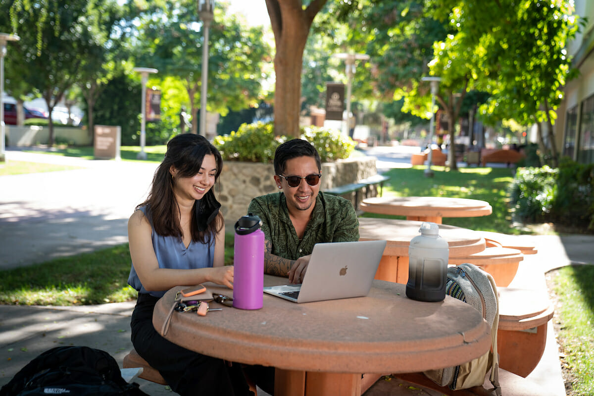 Incoming College of Veterinary Medicine students Eunice Kahng and Ethan Nobles watch part of Orientaion online while on campus early.