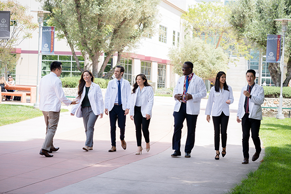 A group of medical students walking down a sidewalk.