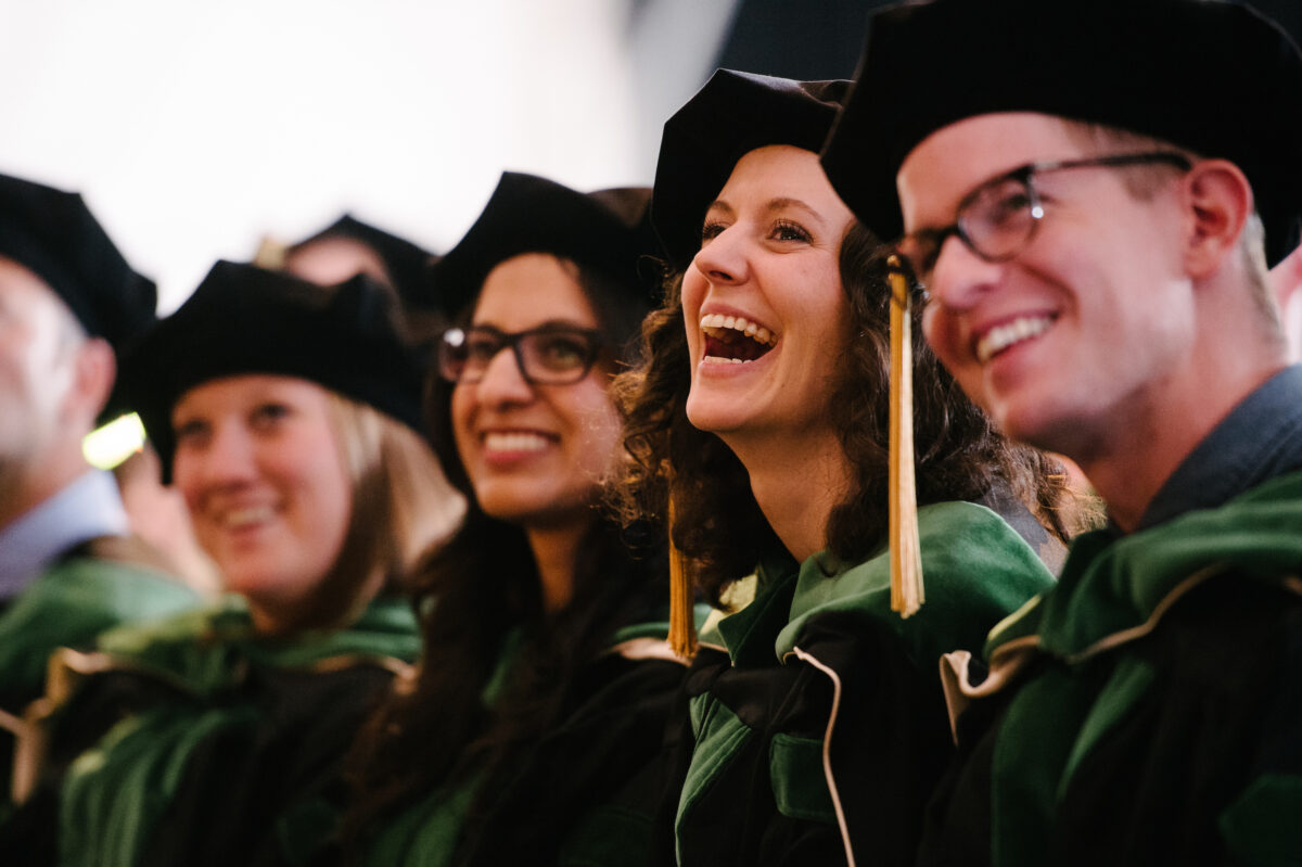 A group of people in graduation robes laughing.