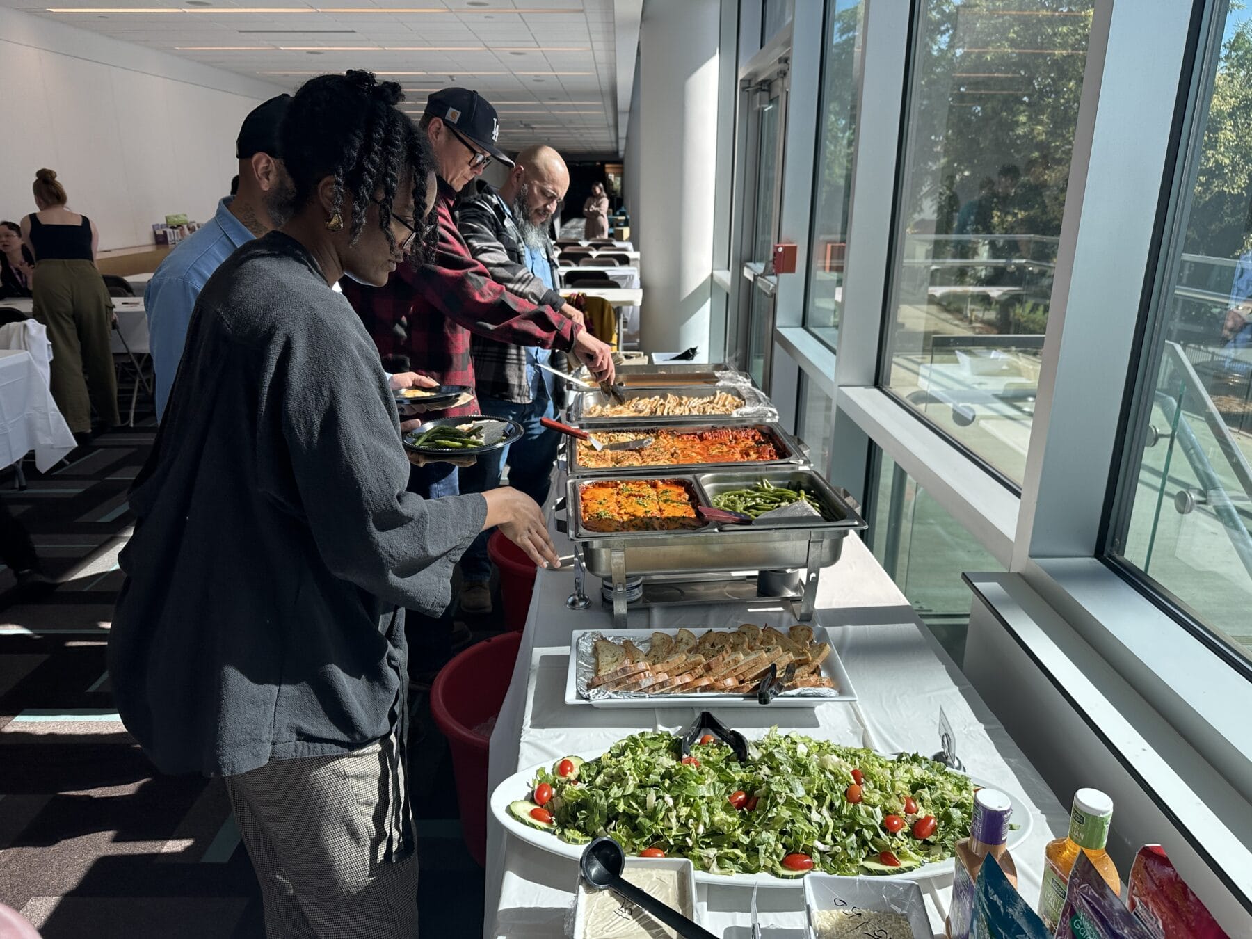 People in a buffet line serving themselves