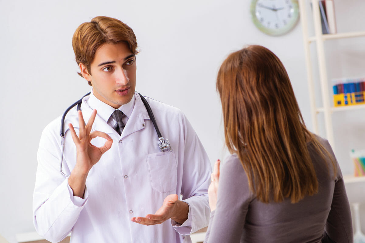 a doctor talking to a woman in a room.