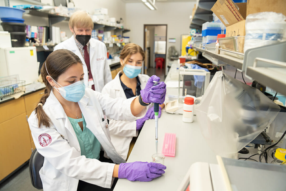 First-year CDM student Lauren Berard uses the pipette in the CDM Research Lab at WesternU Tuesday, March 1, 2022. Fellow Student Alex Graeve and Assistant Dean for Biomedical Curriculu