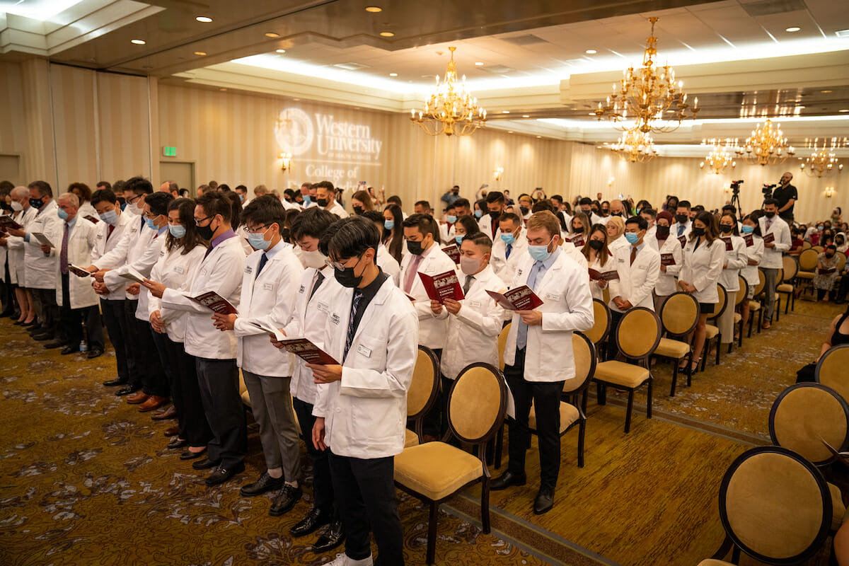 Students in white coat ceremony in hotel conference room