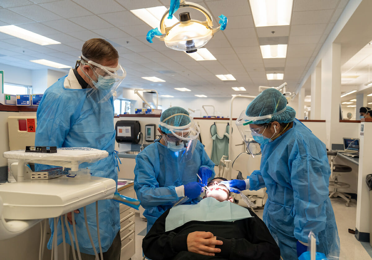 CDM Assistant Professor Grant Burdick, DDS, with fourth-year student Mike “Jau-Jiing” Dai and forth-year IDP studnet Ruchita Shah examine a “patient.”