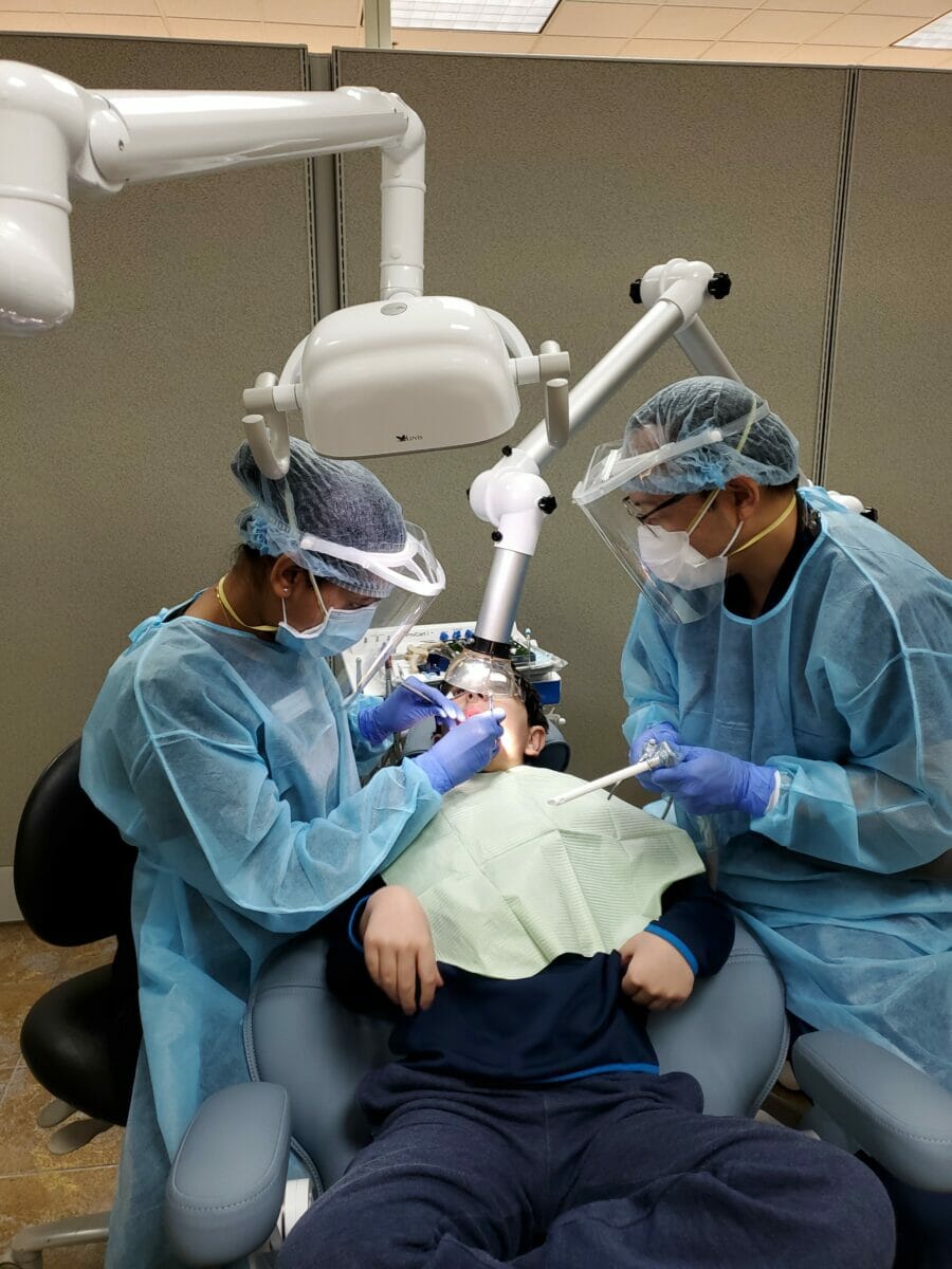 Dental students working on patient in dental care clinic