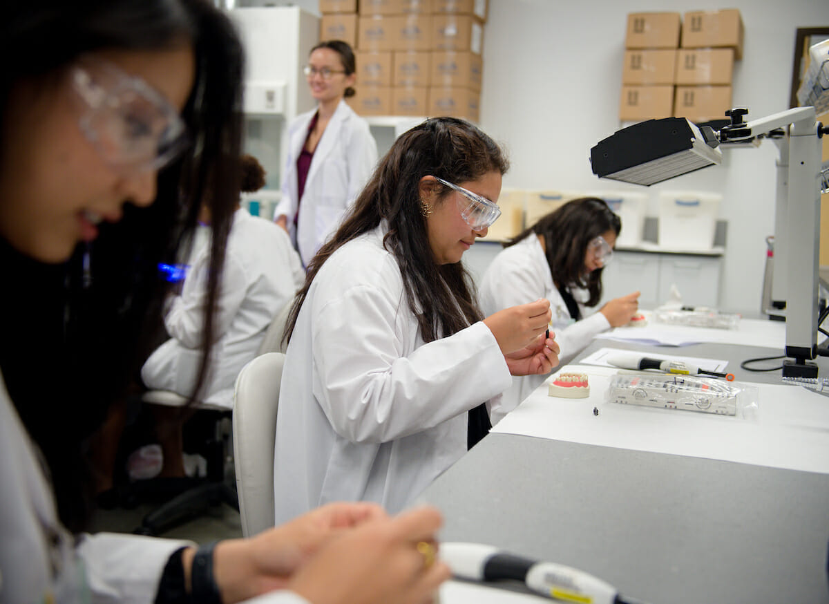 WesternU SHPEP students learn to sculpt a fractured typodont tooth with composite during a dental medicine rotation.