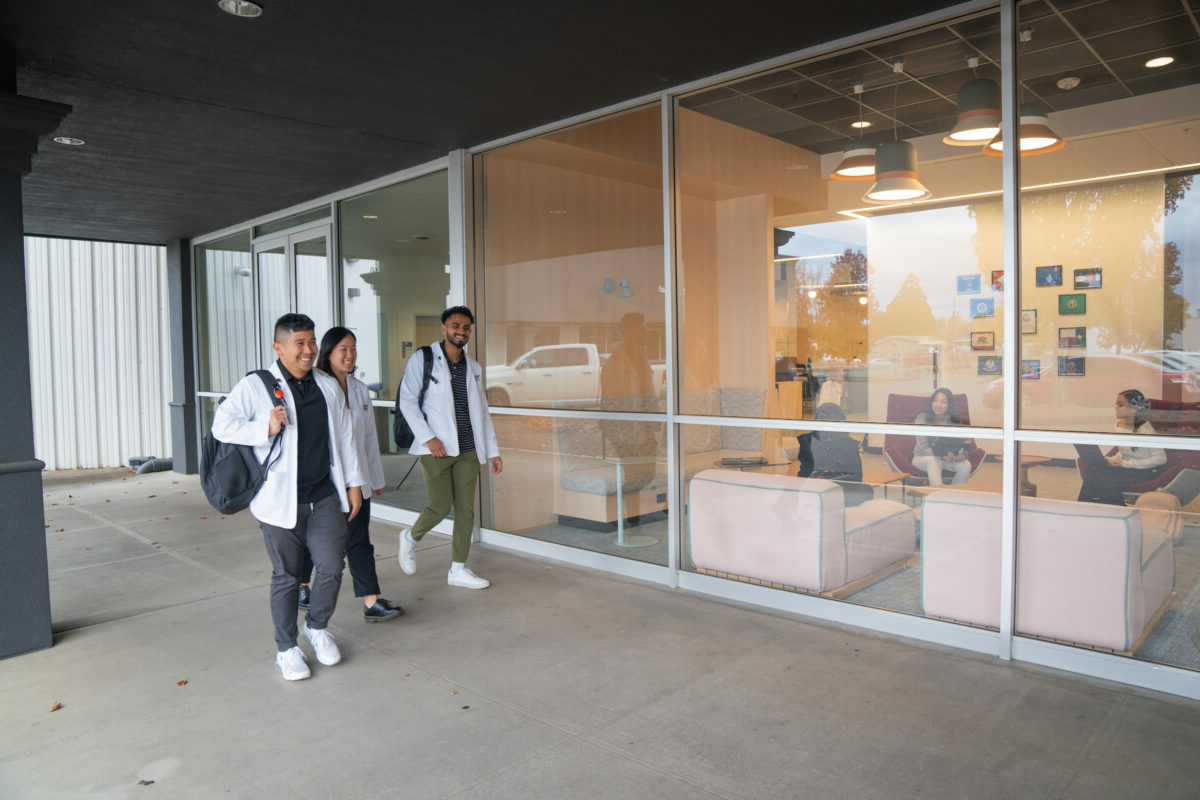 A group of people walking outside of a building.