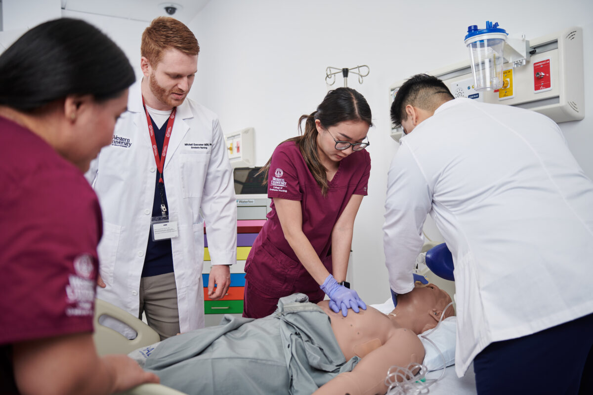 A group of medical students working with a dummy in a hospital.