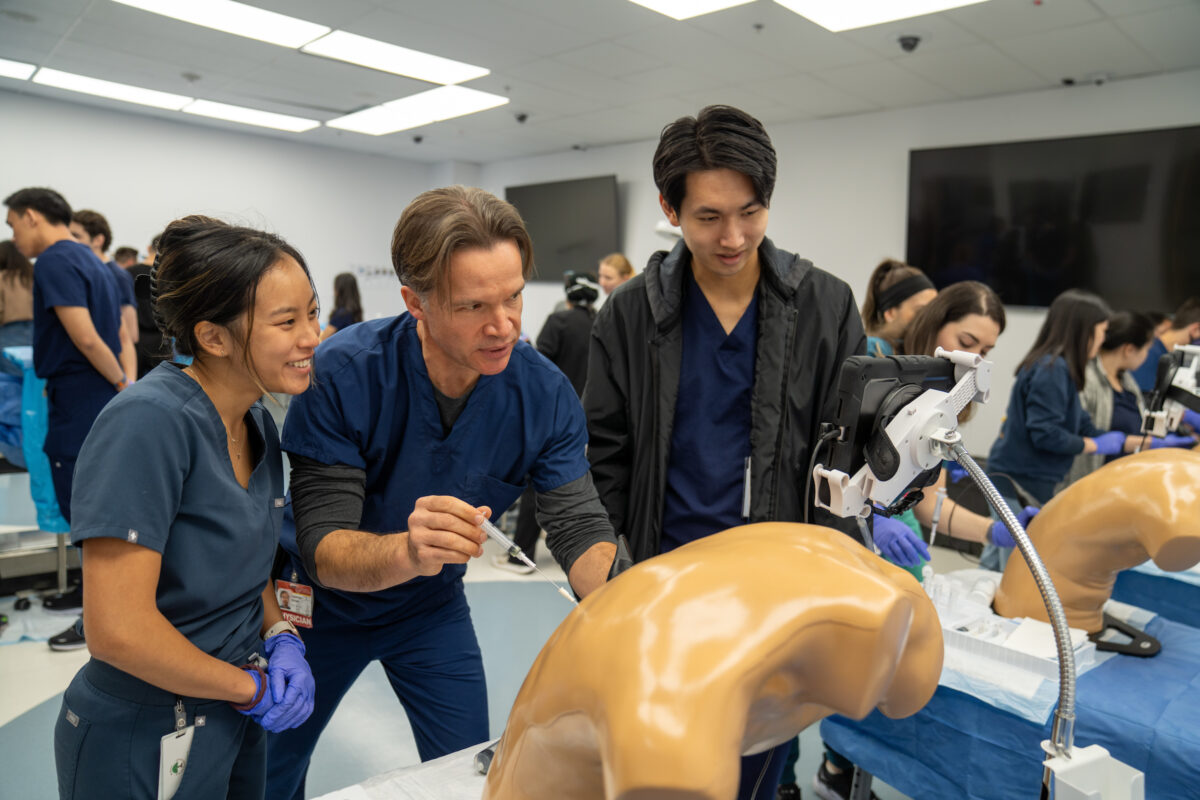 A group of medical students working on a mannequin.