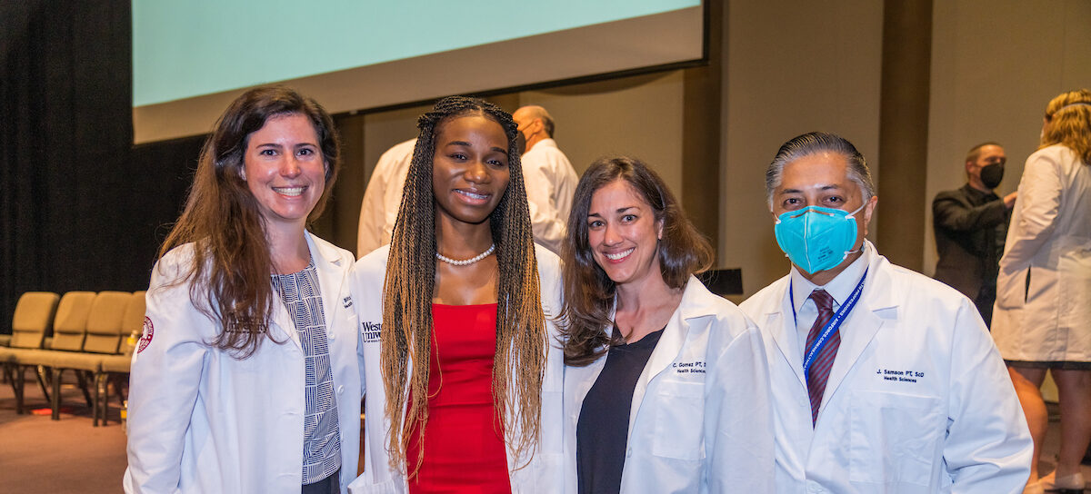 Four women in lab coats posing for a photo.