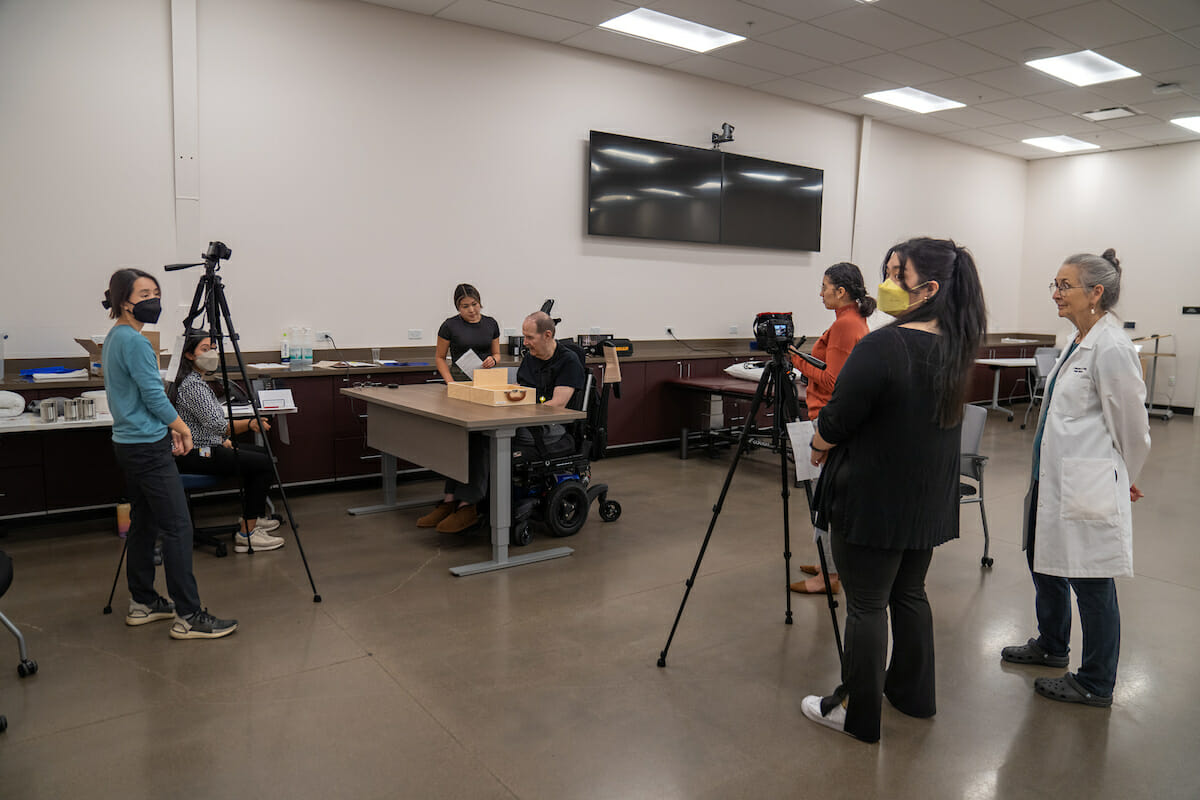 A group of people standing in front of a camera in a room.