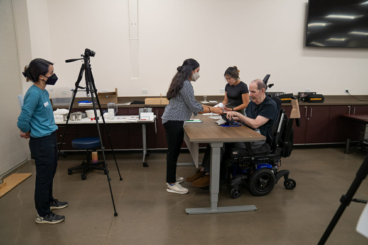 A group of people in a room with a man in a wheelchair.