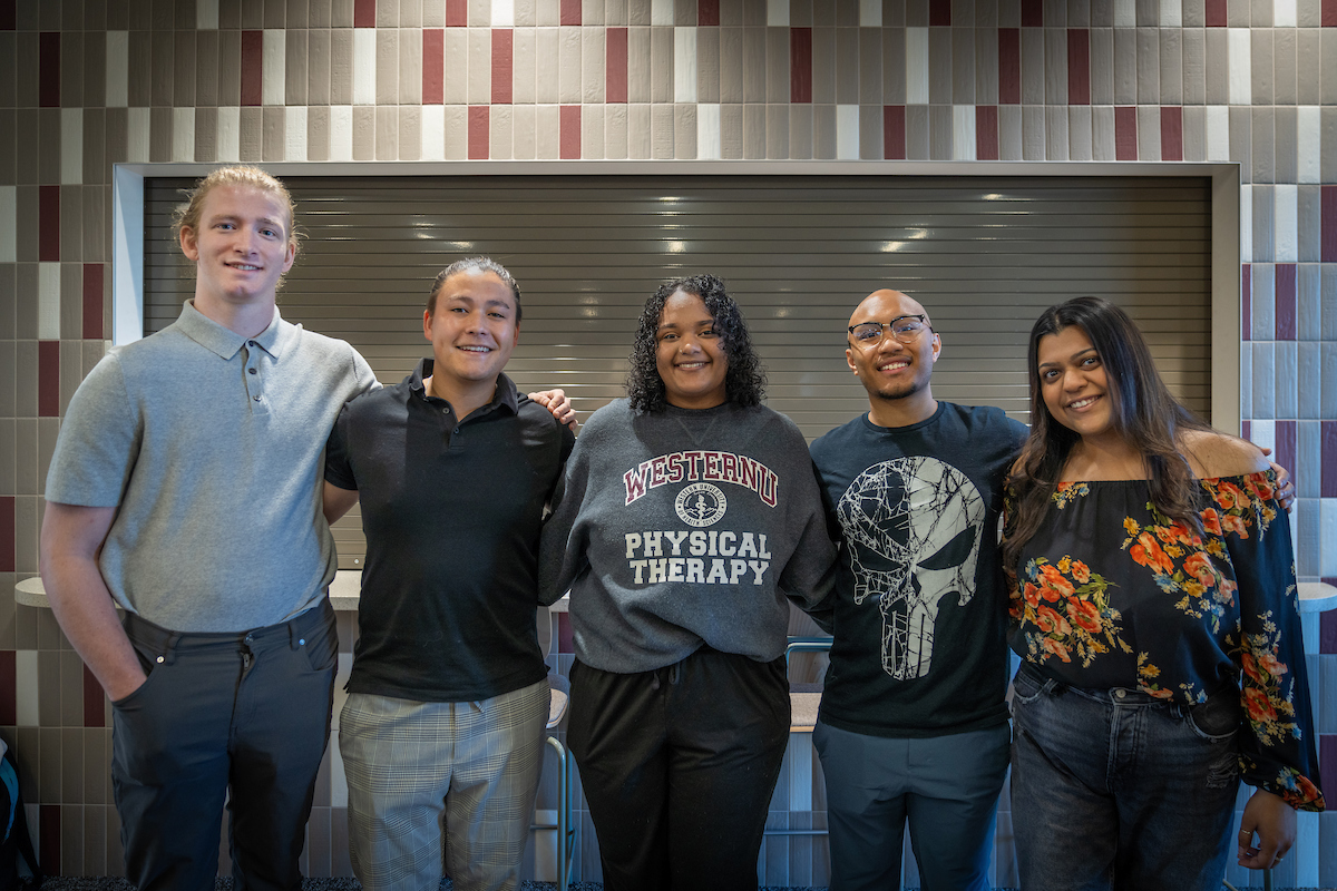 A group of people posing for a photo in a library.