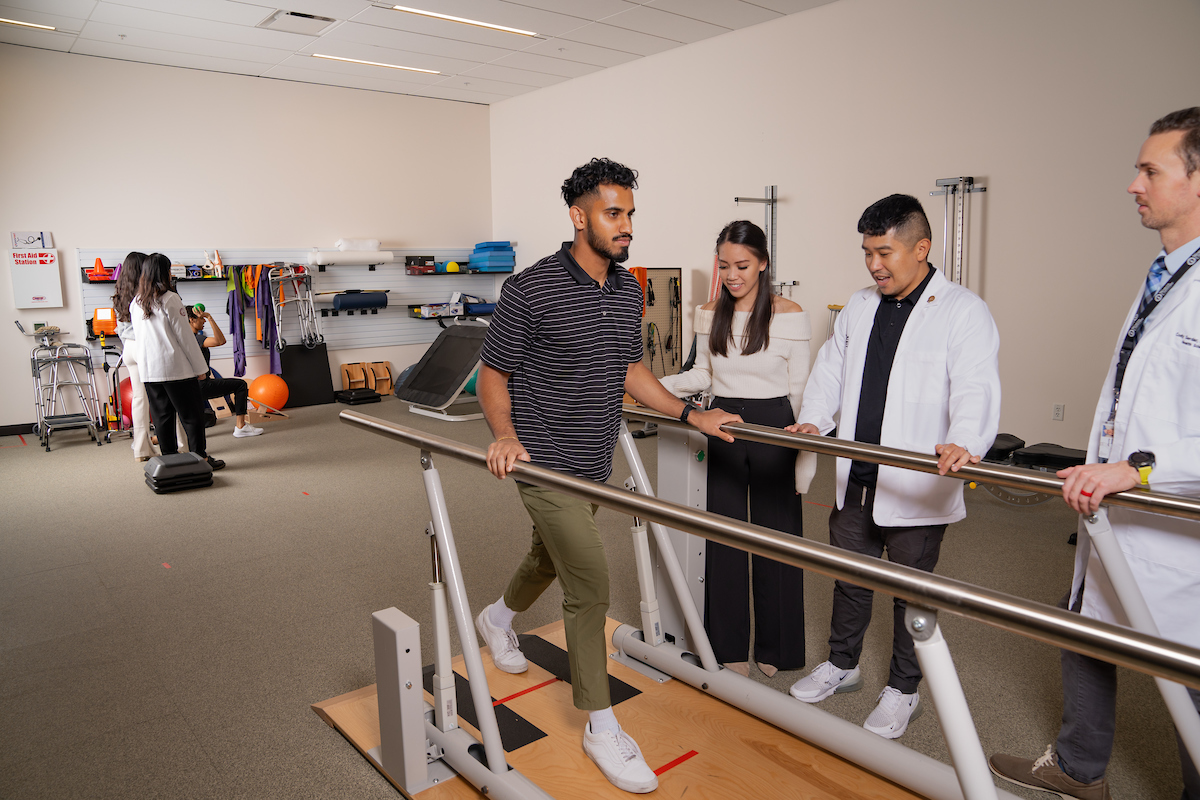 A group of people standing in a room with a doctor and a physical therapist.