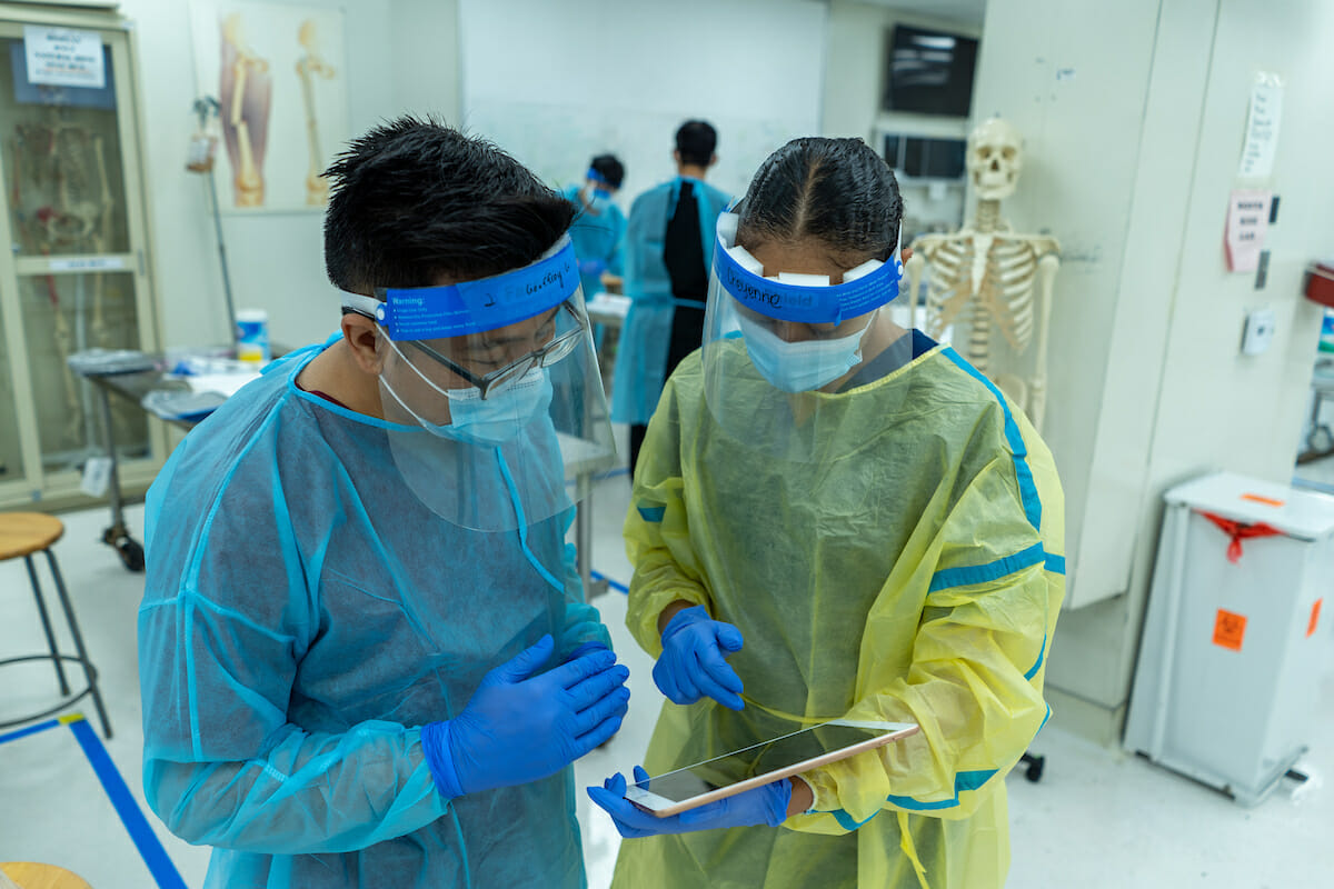 Incoming COMP student Goeffrey Lo reviews anatomy in the Complete Anatomy app on an iPad with COMP student and ISAC TA, Cheyenne Tate, MSMS '21, while in the Gross Anatomy Lab