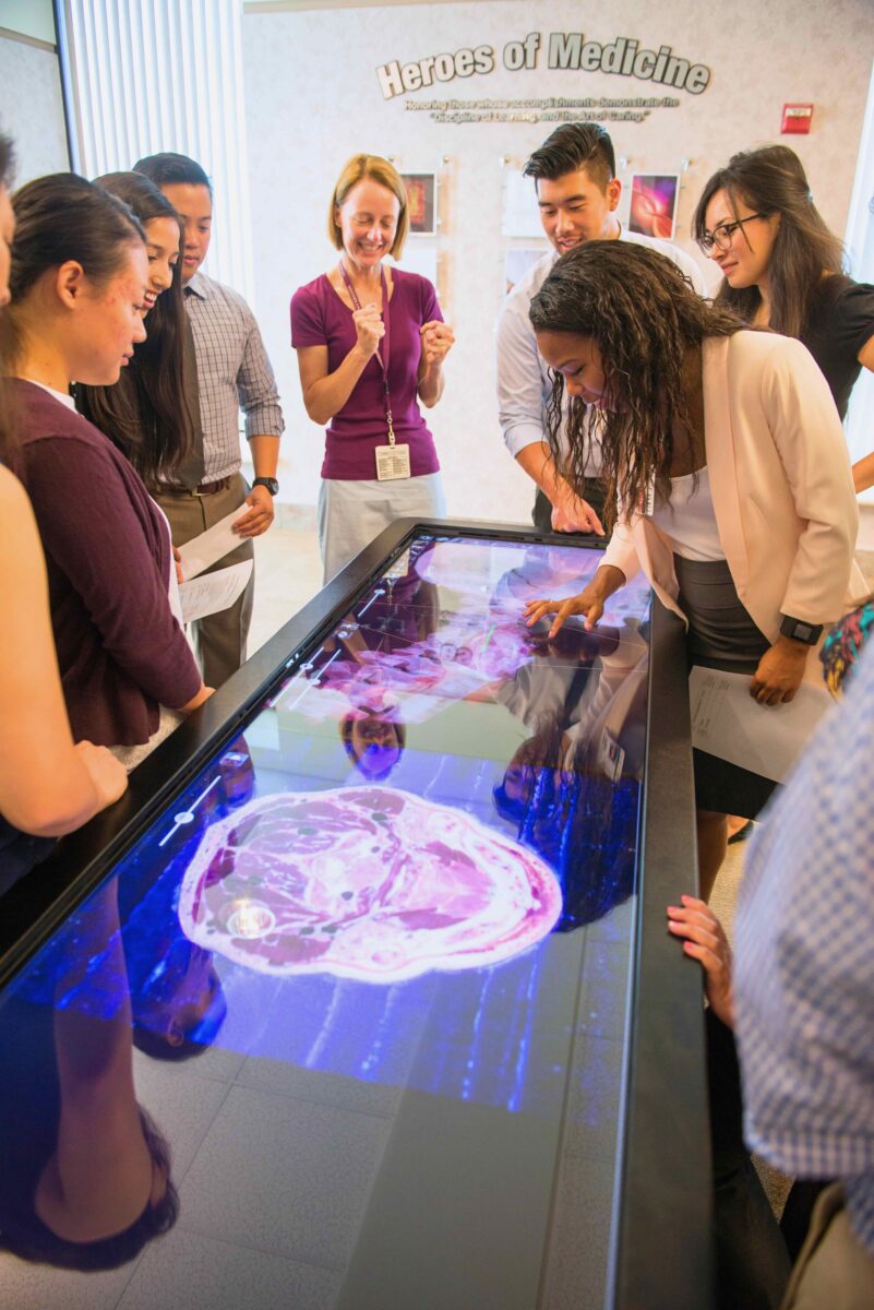 A group of people looking at an interactive table.