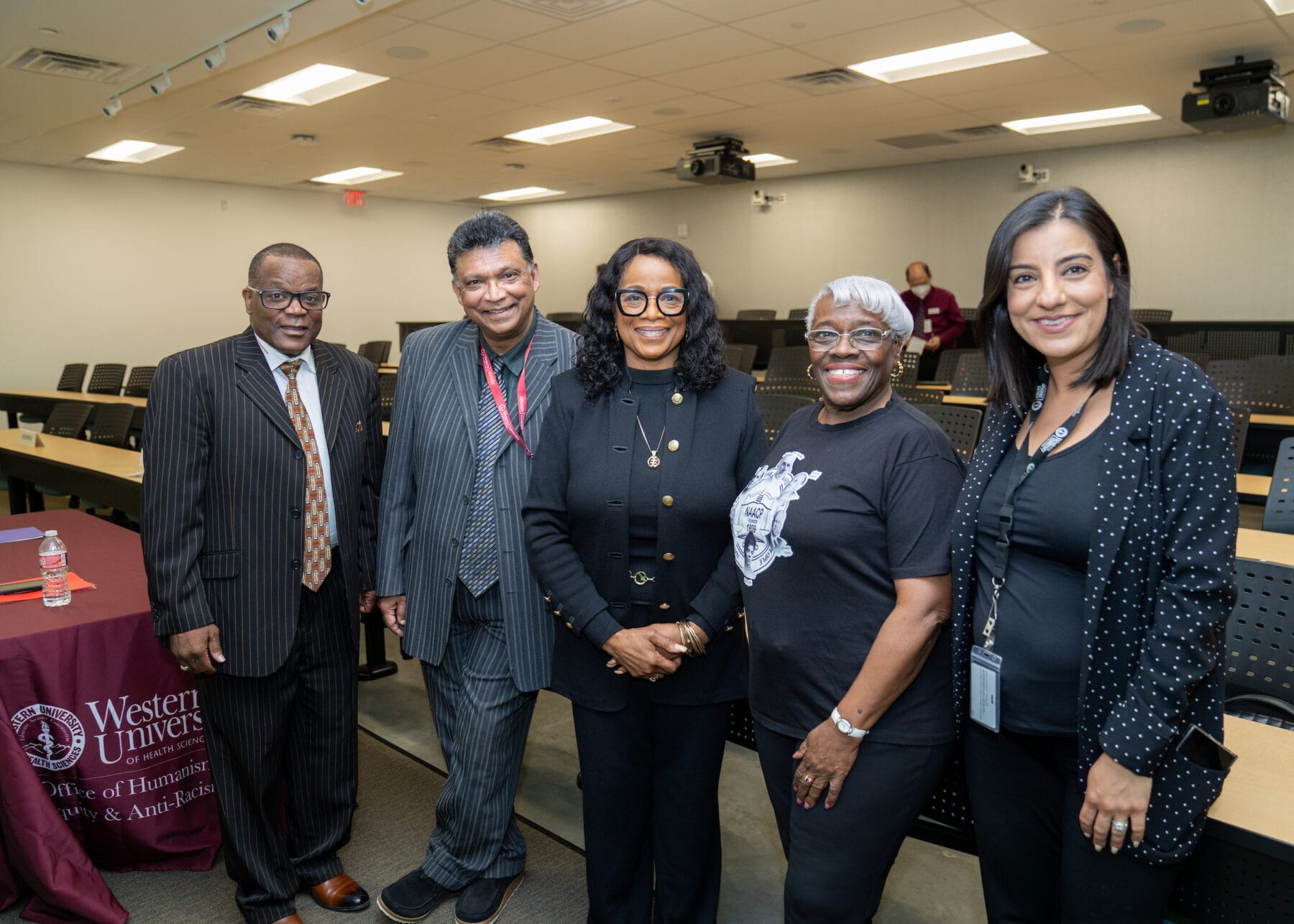 Five people standing, smiling for a photo.