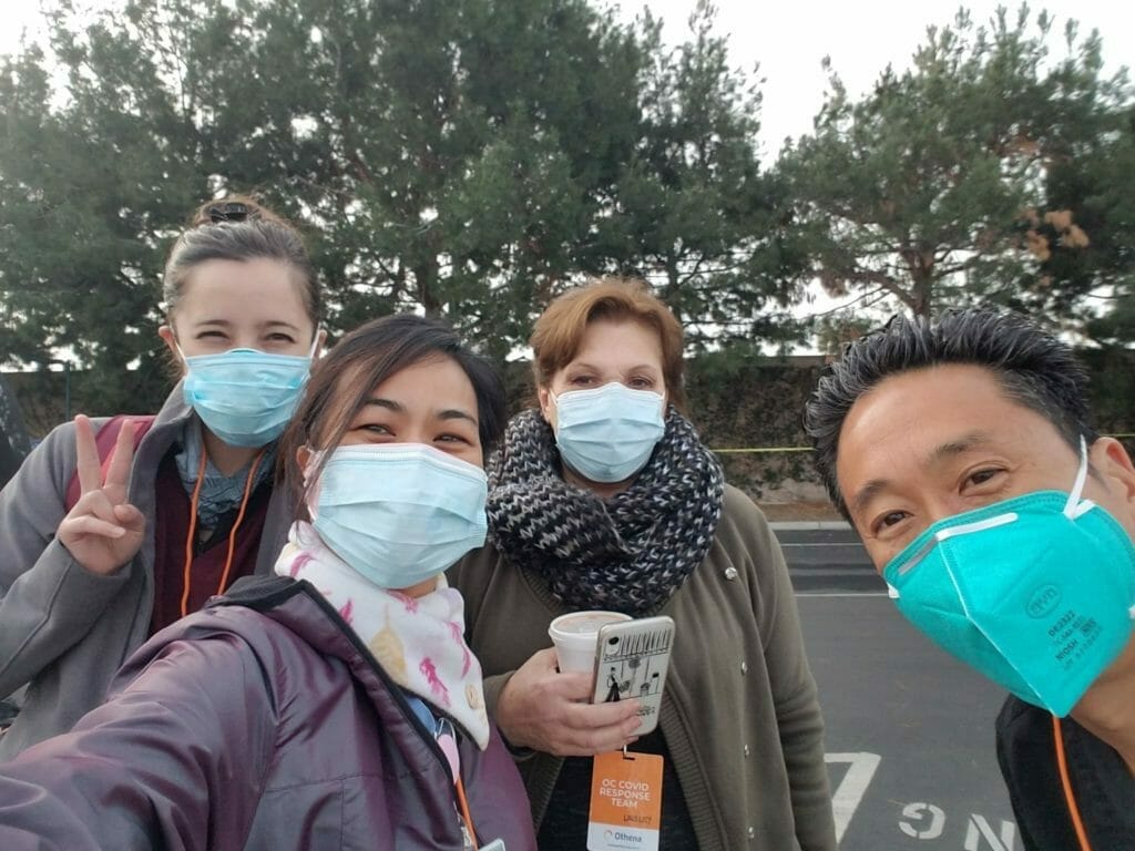 A group of people wearing face masks in a parking lot.