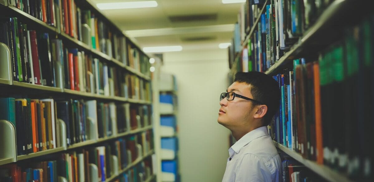 Man looking at book stack