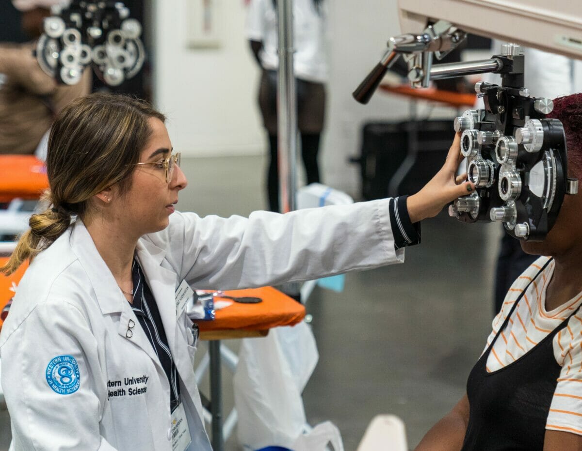student performing eye exam.