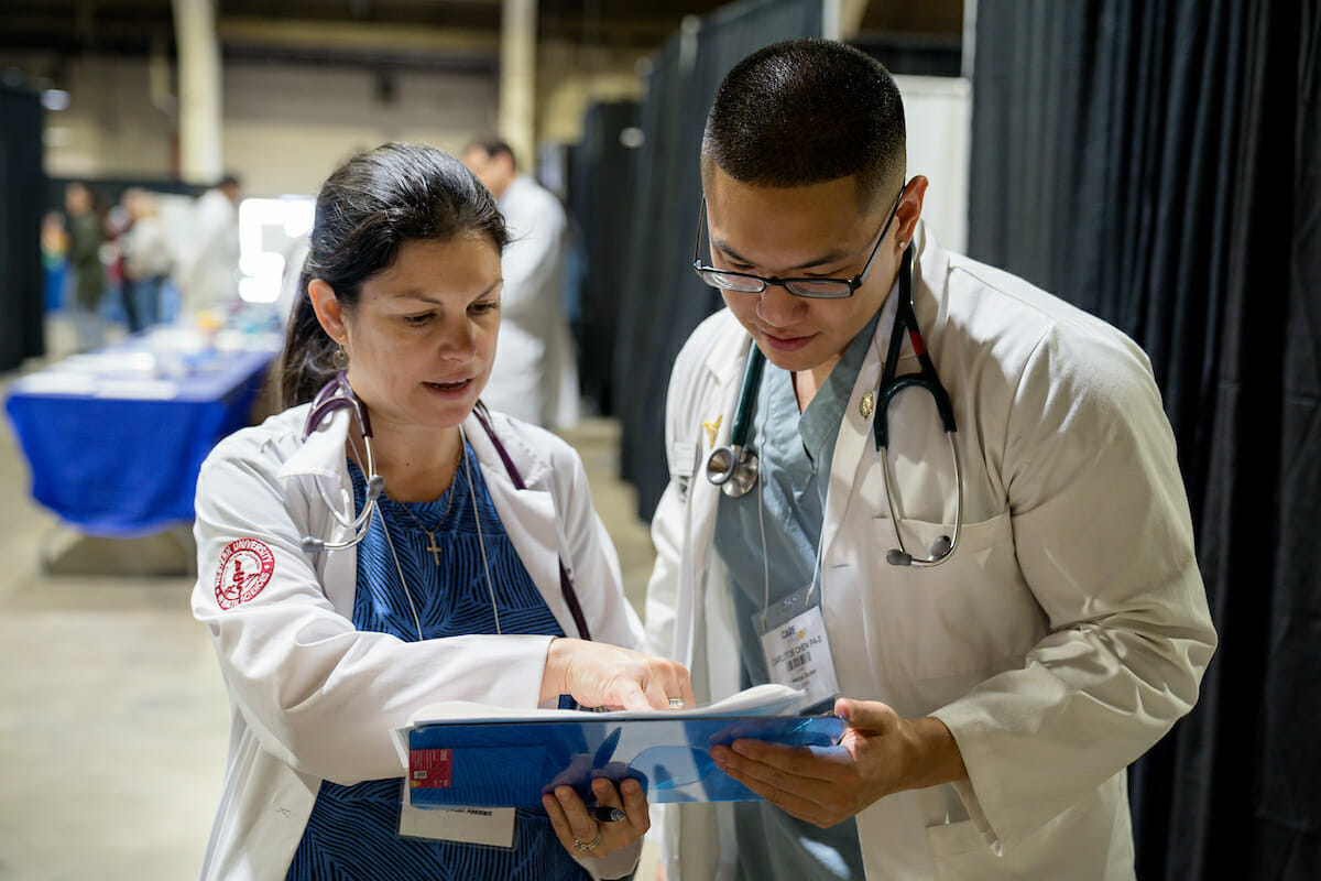 Two doctors looking at a clipboard