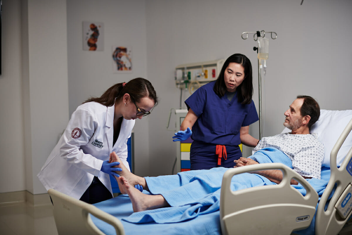 Students examining a standardized patient.