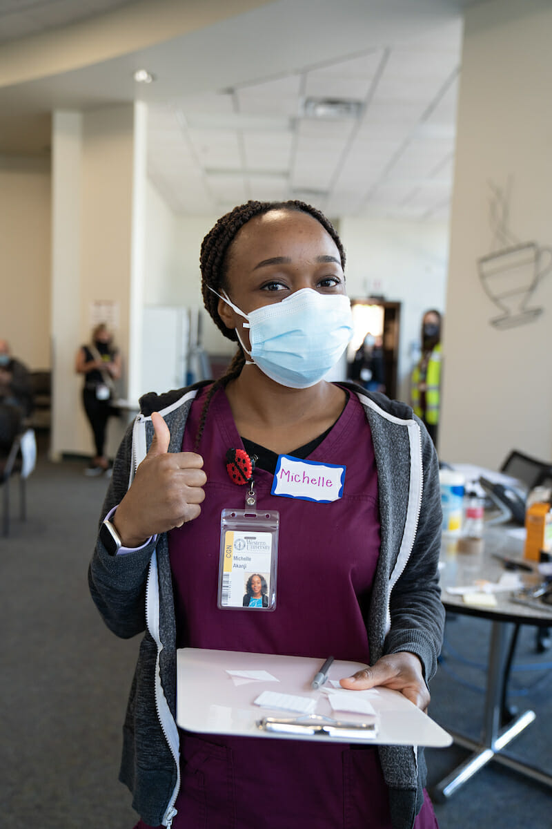 The WesternU Health Vaccine Clinic Thursday. First-year MSN-E student Michelle Akanji volunteers passing out stickers.