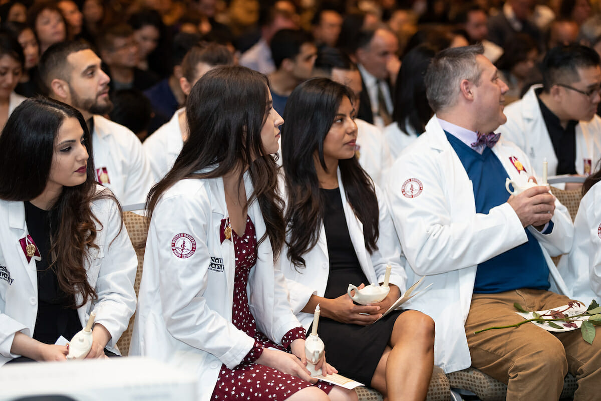 Four students in white coats CGN MSNE Pinning Ceremony