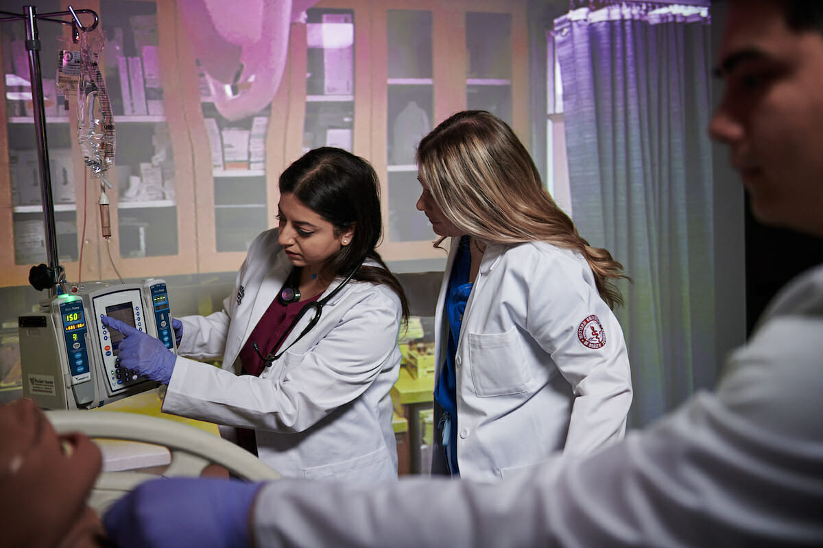a woman in a white lab coat standing next to a woman in a white coat