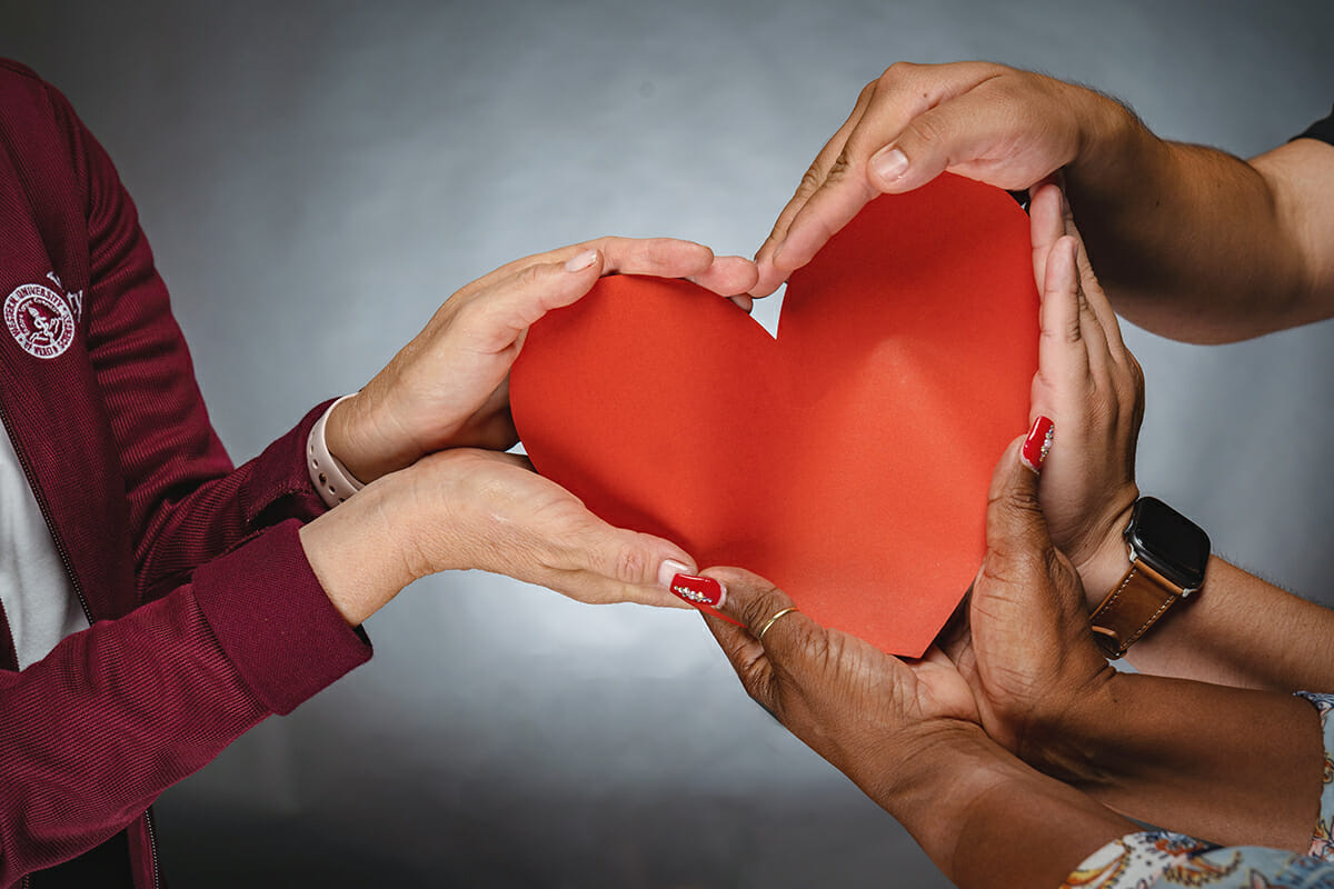 Hands holding a red paper heart