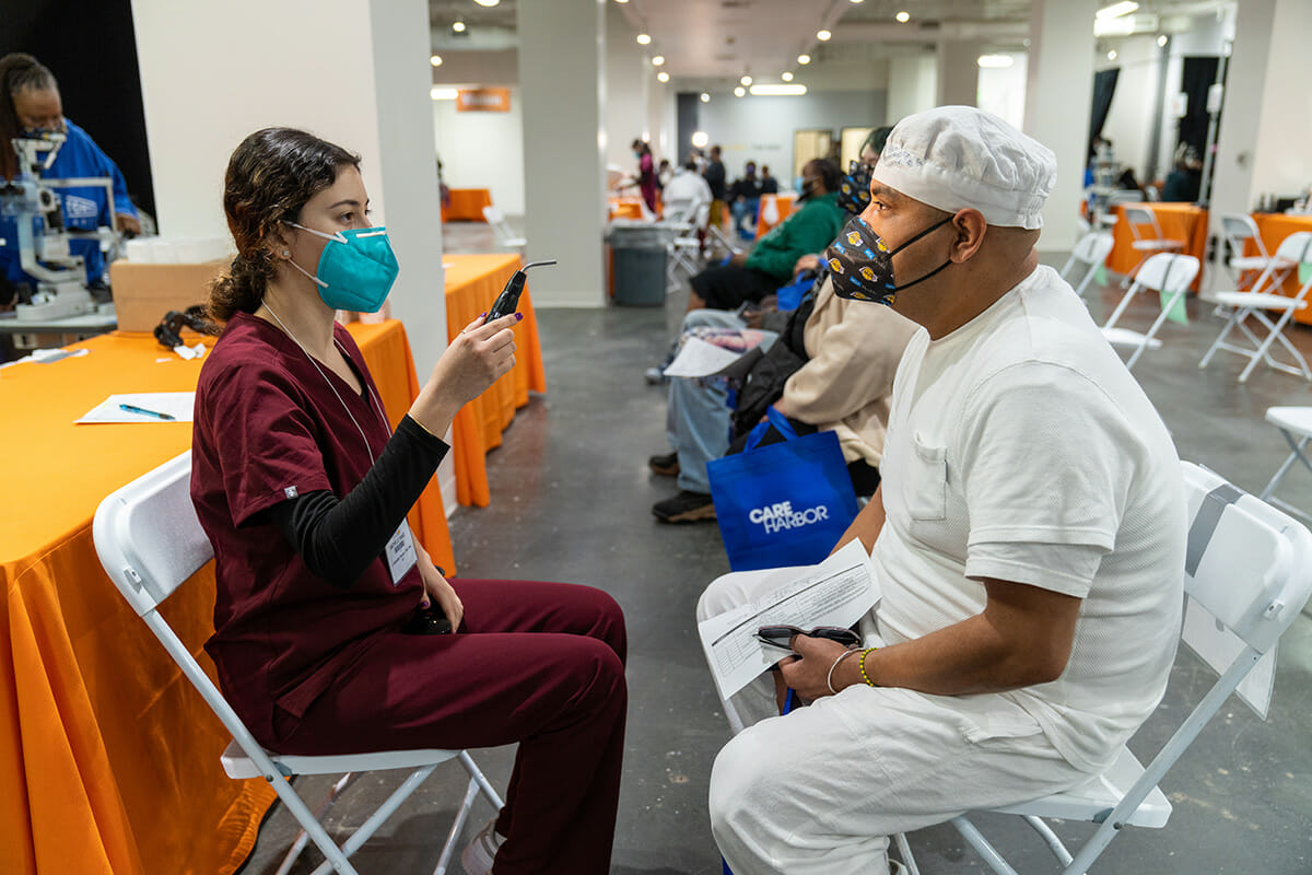 College of Optometry student Michelle Raad give an eye exam to patient Antonio Vervantes of Inglewood.** See Note in Instruction in Origin ** WesternU students, faculty, staff and alumni from the colleges of optometry, dental medicine, podiatric medicine and osteopathic medicine provided free care to those in need during the first day of the Care Harbor mega clinic at The Reef in downtown Los Angeles Friday, March 4, 2022. WesternU volunteers are serving at Care Harbor through the weekend.