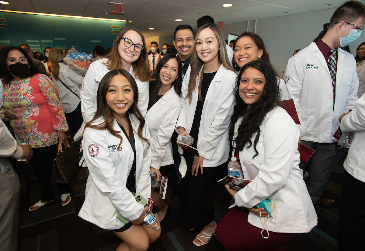 7 students in white coats posing for white coat ceremony