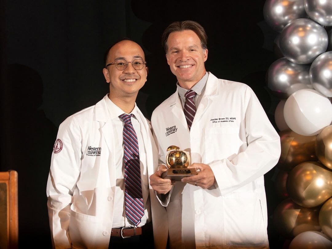 Two researchers in white lab coats standing together.