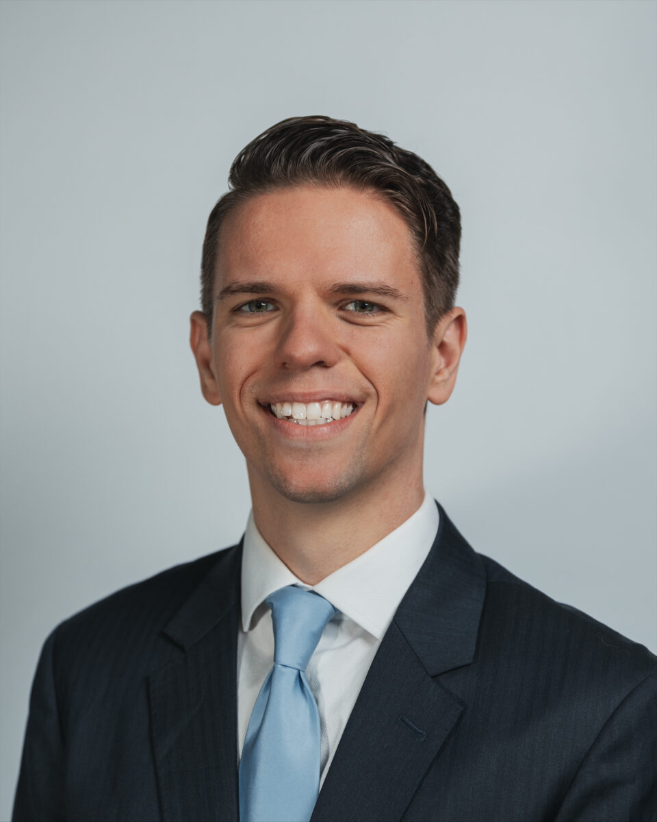 A smiling man in a suit and tie.