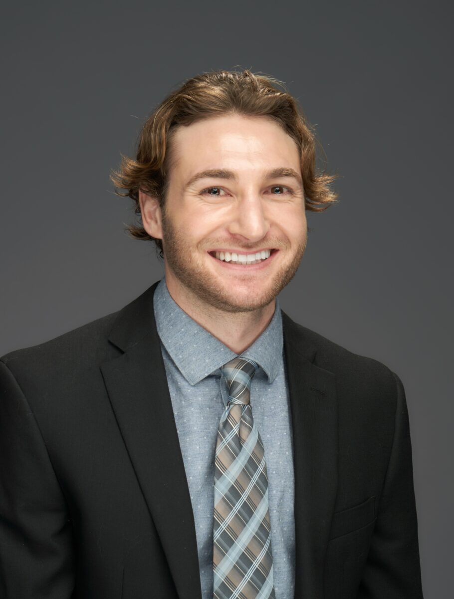 A smiling man in a suit and tie.