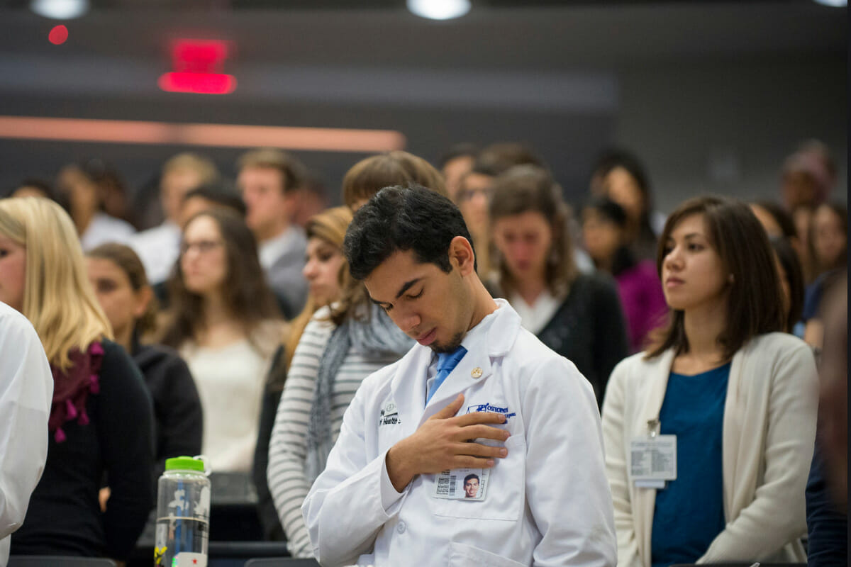 student with hand over heart