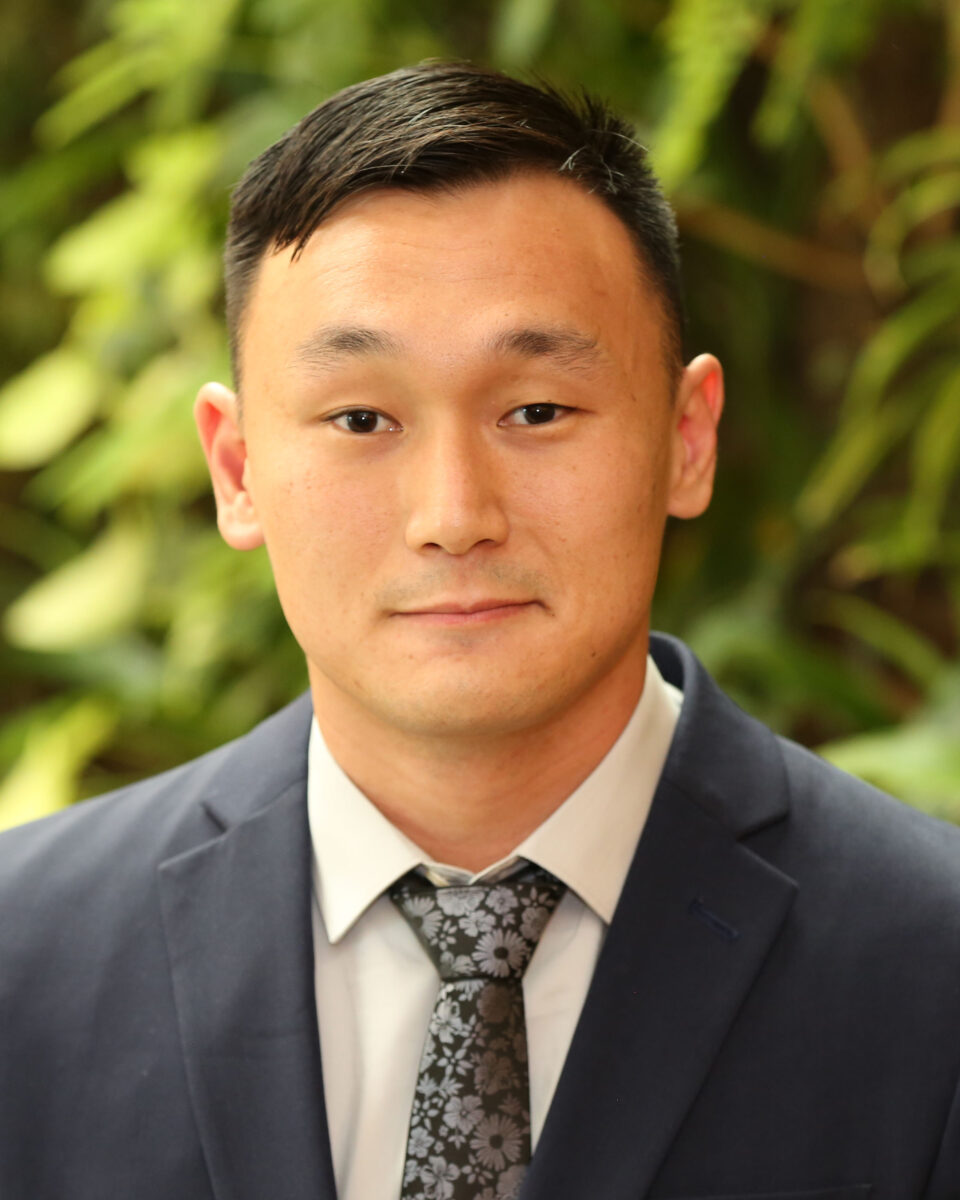 An asian man in a suit and tie.