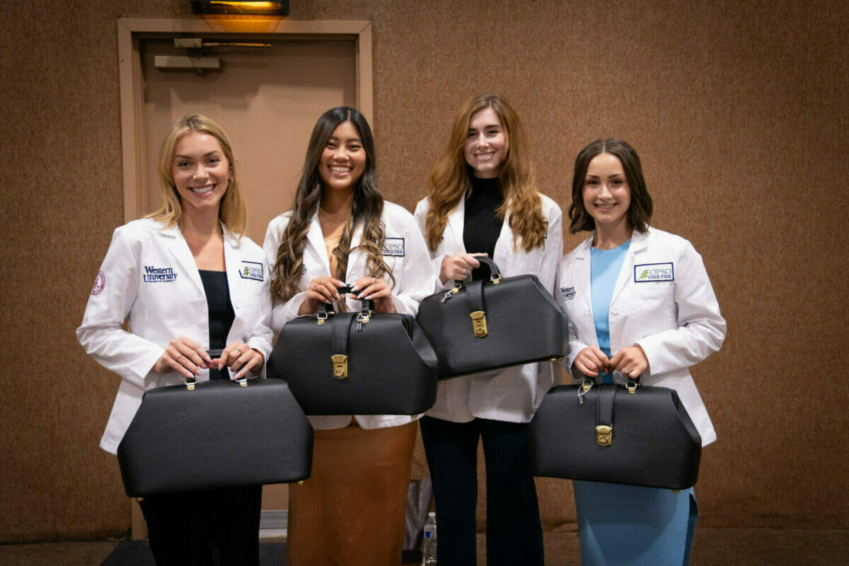 Photograph of four women in white lab coats.