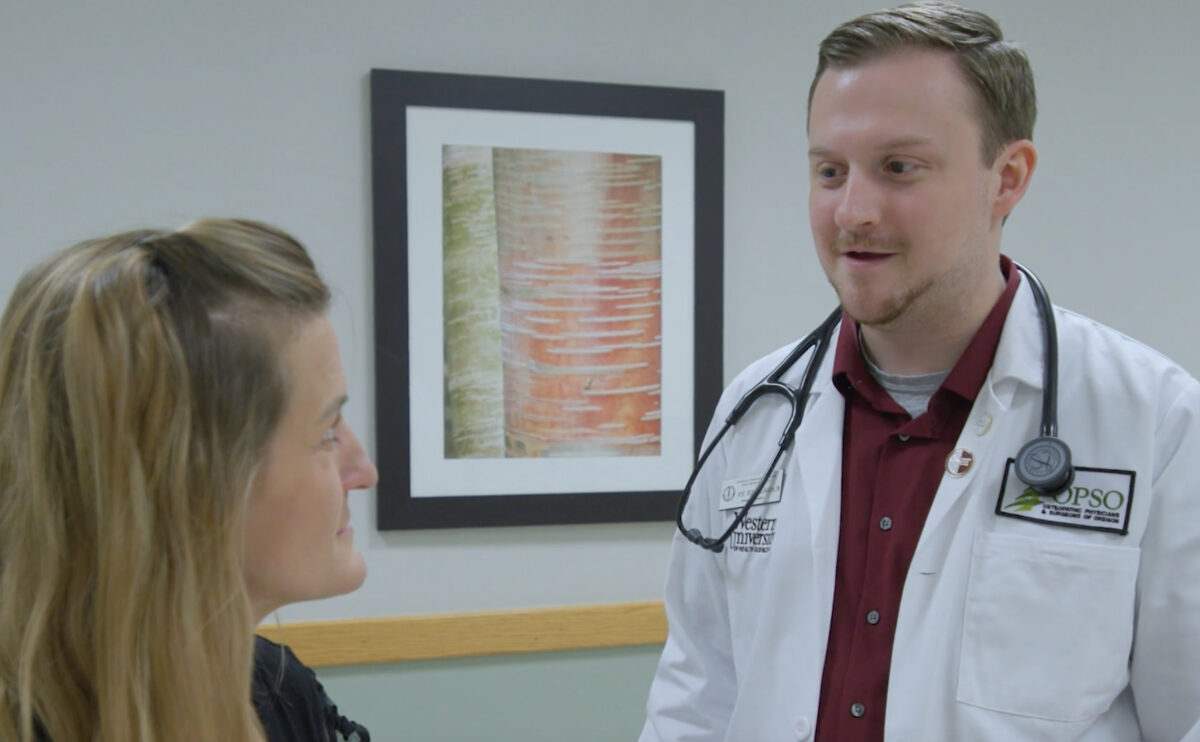 A doctor talking to a woman in an office.