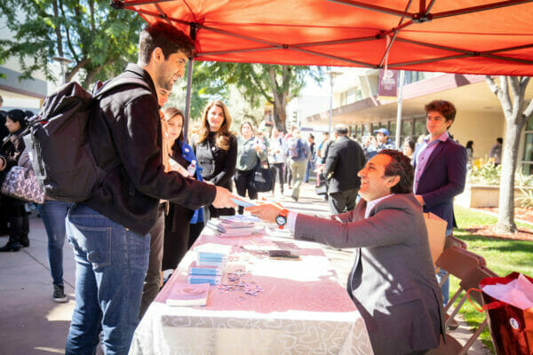 a man shakes hands with a man at a table.