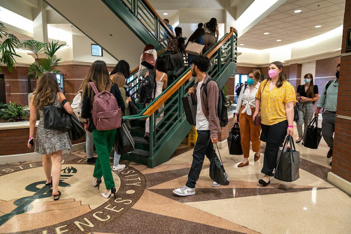 a group of people walking down stairs in a building.