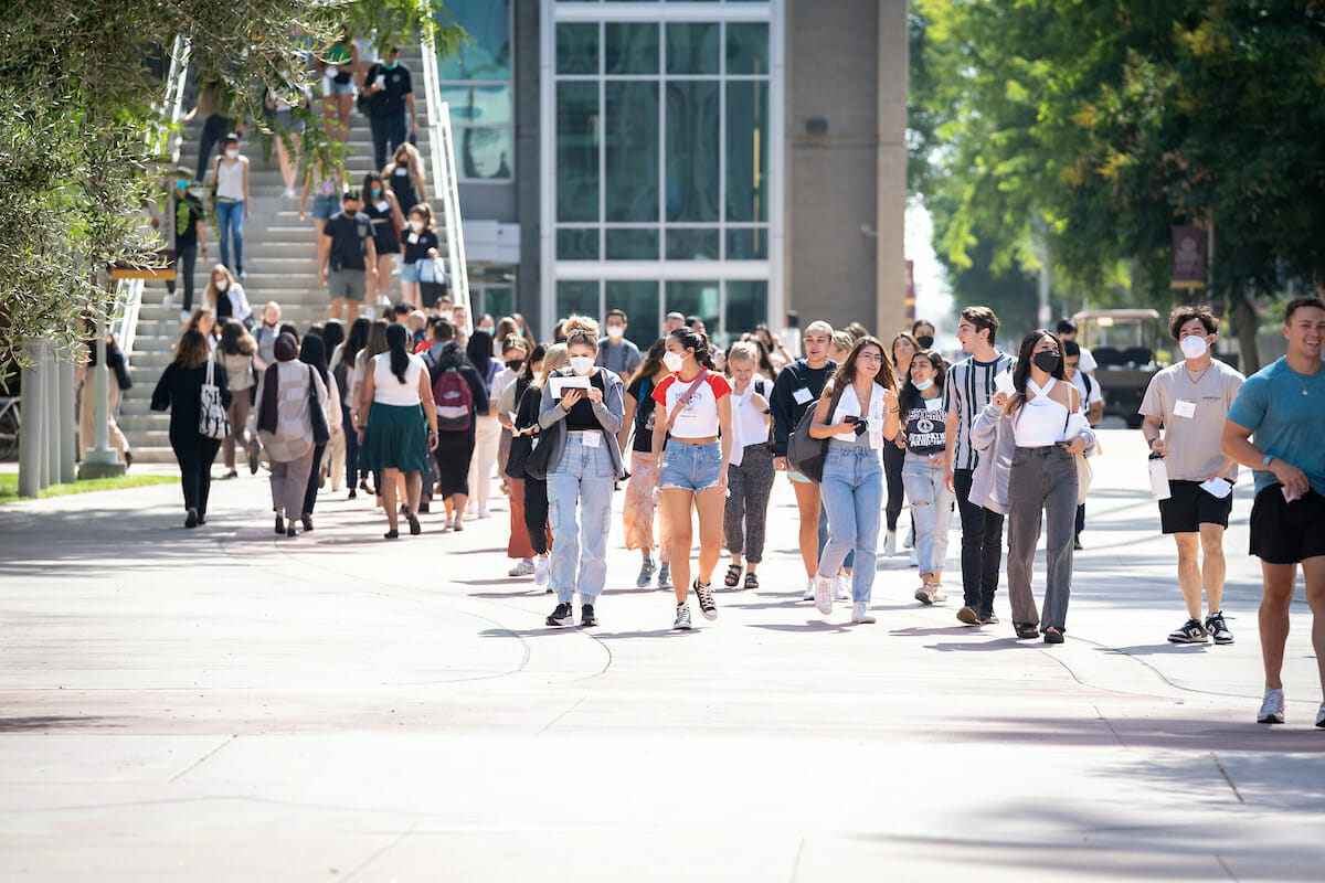 a group of people walking down a sidewalk.