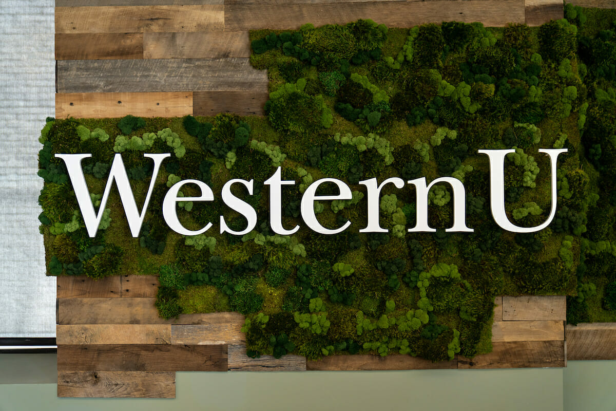 western u logo with moss on the wall.