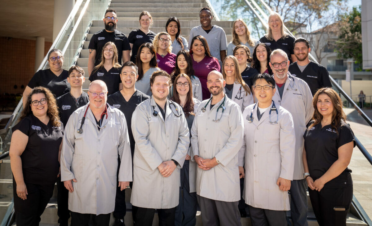 WesternU Pet Health Center team of RVTs, Clinical Staff, and Veterinarians standing together on the steps of a building