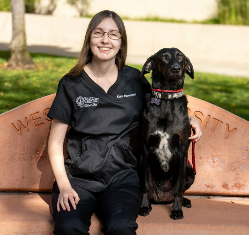 Clinical Front Desk Receptionist/Cashier Kerri Taylor sitting with her pet dog on a bench outside the PHC