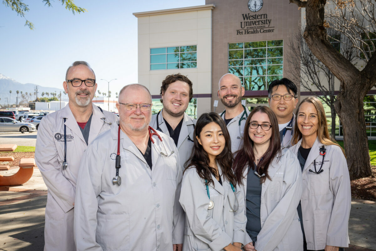A group of WesternU PHC Veterinarians outside with the WesternU PHC in the background