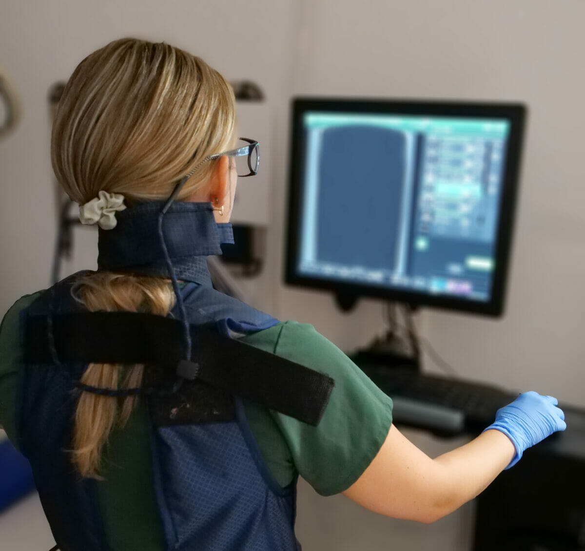 A woman wearing a neck brace in front of a computer.