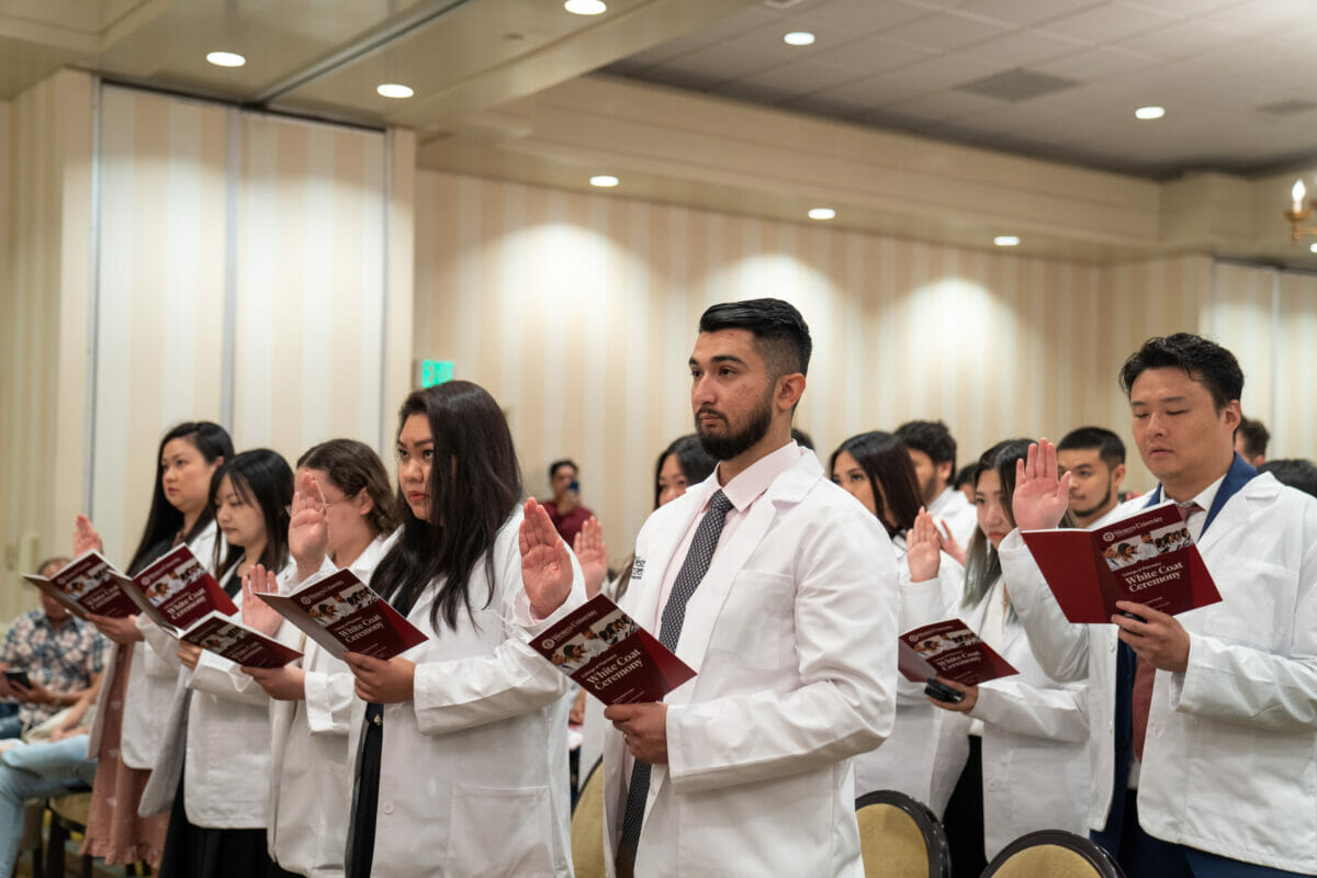 A team of scientists in lab coats gathered in a room.