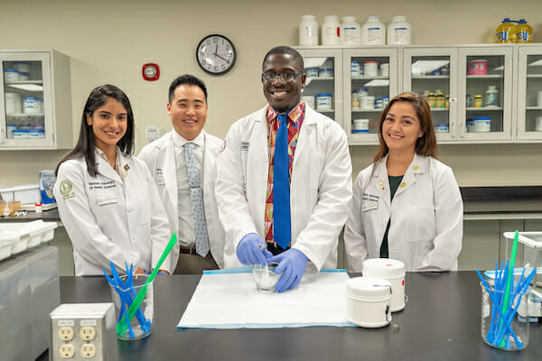 4 students in whitecoats, College of Pharmacy