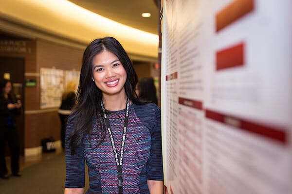 student smiling on front of her presentation